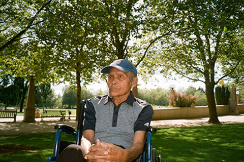 Decorative photo of elderly man sitting on a park bench.